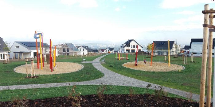 Foto: Spielplatz Marbacher Höhe/Treppenweg © Stadtverwaltung Erfurt Blick auf die Spielflächen mit Geräten. Im Hintergrund Einfamilienhäuser