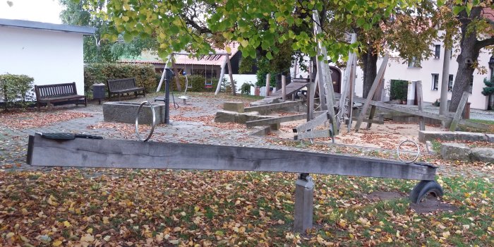 Foto: Spielplatz Am Lindenplatz: Wippe, Brunnen, Doppelschaukel und Klettergerüst © Stadtverwaltung Erfurt Wippe aus Holz mit zwei Sitzen, Brunnen mit Pumpe, Schaukel mit zwei Sitzen und Klettergerüst aus Holz