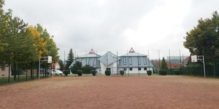 eingezäunter Bolzplatz mit Fussballtoren und zwei Basketballkörben