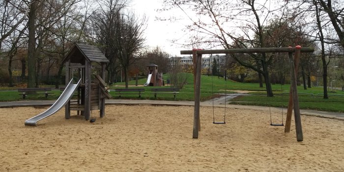 Foto: Spielplatz Györer Straße: Rutschenturm und Doppelschaukel © Stadtverwaltung Erfurt große Sandfläche mit Rutschenturm aus Holz und Schaukel mit zwei Sitzen