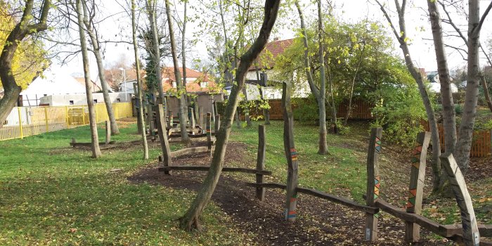 Foto: Spielplatz Ringstraße © Stadtverwaltung Erfurt Pfosten und Balken zum Balancieren auf einem mit Bäumen gepflanzten Spielraum