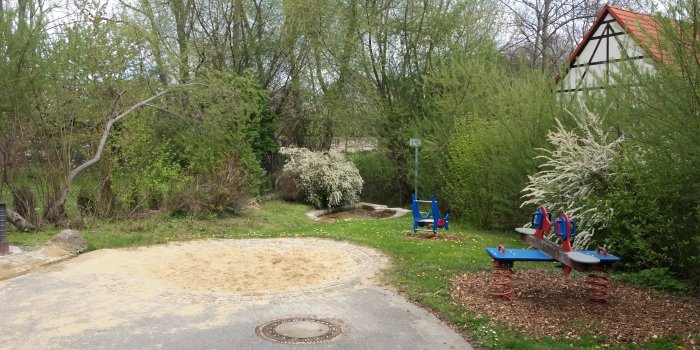 Foto: Spielplatz Brunnenstraße: Sandmulde, Federtier und Federwippe © Stadtverwaltung Erfurt kleine Sandmulde, blaues Federtier in Form eines Delphins und blau-rote Federwippe mit zwei Sitzen in Form eines Hundes