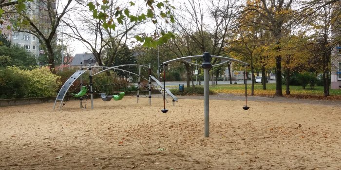 Foto: Spielplatz Juri-Gagarin-Ring: Karussell und Kletterkombination © Stadtverwaltung Erfurt große Sandfläche mit Klettergerüst aus Metall und Karussel mit zwei Sitzen