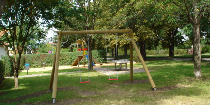 Foto: Spielplatz Friedensallee © Stadtverwaltung Erfurt Schaukel und Turmhaus mit Bäumen umgebenden Platz