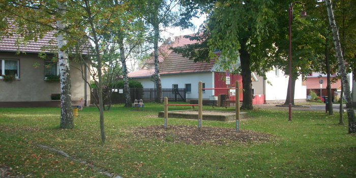 Foto: Spielplatz Am Alten Backhaus © Stadtverwaltung Erfurt Federtiere, Reck, Sandkasten umgeben von Bäumen