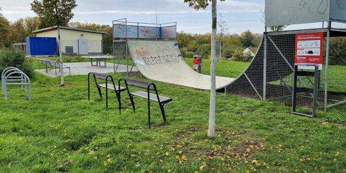 eine Halfpipe, daneben Sitzbänke