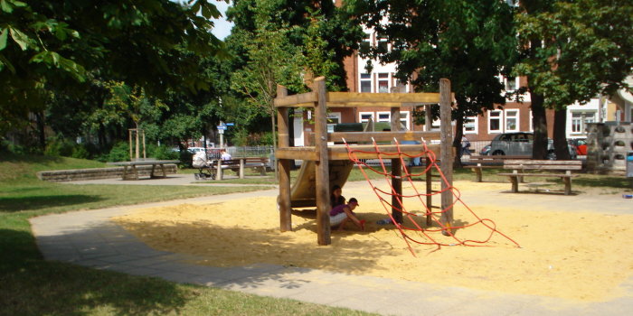 aus massiven Balken bestehende Kombispielgerät innerhalb einer Sandfläche