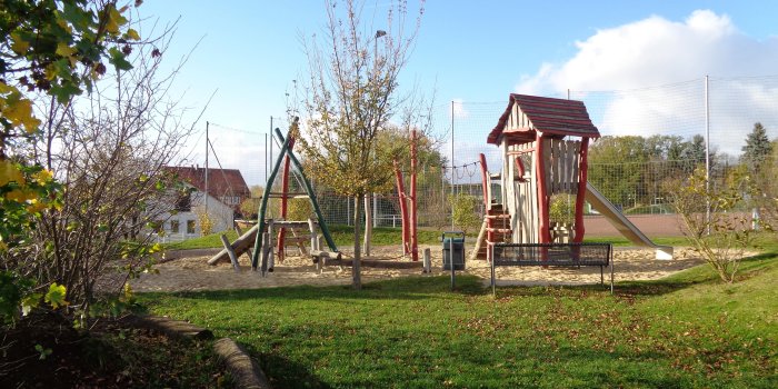 große Sandfläche mit Kletterturm und Klettergerüst aus Holz