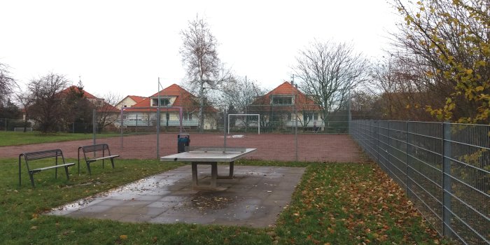 Foto: Bolzplatz Luckenauer Straße © Stadtverwaltung Erfurt Tischtennisplatz mit Sitzbänken und eingezäunter Bolzplatz im Hintergrund