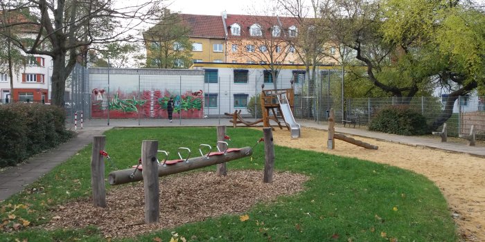 Foto: Spiel- und Bolzplatz Stollbergstraße: Bolzplatz, Rutschenturm und Tampenschaukel © Stadtverwaltung Erfurt kleiner eingezäunter Bolzplatz, Sandfläche mit Rutschenturm aus Holz und Schaukel mit vier Sitzen