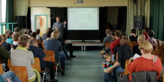 Foto: Bürgerbeteiligung zur Entwicklung der äußeren Oststadt © Büro für urbane Projekte Personen verfolgen eine Präsentation in einem Raum