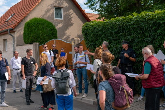 Menschengruppe begeht Gebiet auf Straße mit Redner.
