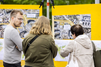 Das Bild zeigt Besuchende im Gespräch mit Mitarbeitenden der Stadtverwaltung und Zebralog vor einer Infotafel