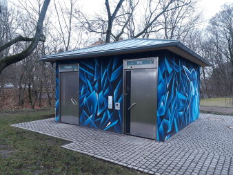 Foto: Öffentliche Toilette: Skaterpark im Nordpark © Stadtverwaltung Erfurt Quadratischer Flachbau mit Schrägdach aus Metall, Eingangstüren aus Edelstahl und Graffiti in Blautönen an Fassade