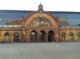 historische Empfangshalle mit gelben Klinkern, rotem Sandsteinmauerwerk und drei gläsernen Eingangstüren