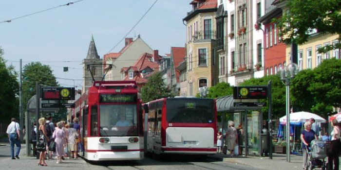 Es ist eine Straßenbahn und ein Bus der EVAG an der Haltestelle Domplatz-Nord dargestellt.