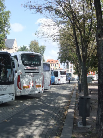 Es sind Reisebusse am Domplatz dargestellt.