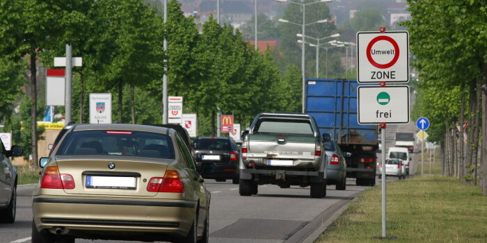 Verkehrsschild zur Umweltzone an stark befahrener Straße.