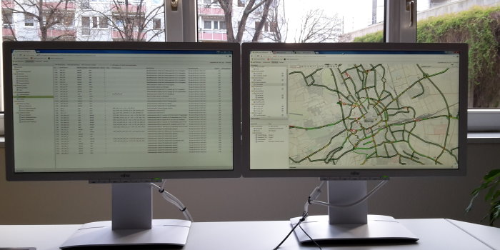 zwei Monitore mit textlicher und geografischer Darstellung