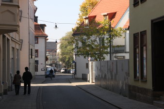 Fußgänger und Radfahrer zwischen Häuserzeilen