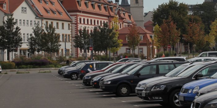 Eine Reihe parkender Fahrzeuge und im Hintergrund Gebäude