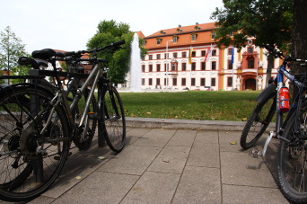Fahrradbügel mit angeschlossenen Fahrrädern und im Hintergrund die Staatskanzlei