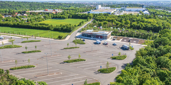 Dargestellt ist eine Luftaufnahme des Reisebusparkplatzes Wartburgstraße mit dem Mehrzweckgebäude