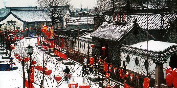 Eine winterliche Straße mit roten Lampions geschmückt