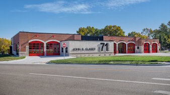 Feuerwehrstation – Gebäude mit roten Toreinfahrten und Schriftzug