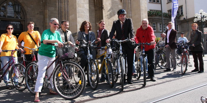 Oberbürgermeister Andreas Bausewein, Vertreter des Erfurter Stadtrates und Mitarbeiter der Stadtverwaltung stehen mit ihren Fahrrädern vor dem Rathaus.