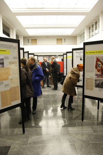 Foto: Austellungseröffnung © Stadtverwaltung Erfurt Menschen stehen vor den Schautafeln einer Ausstellung.