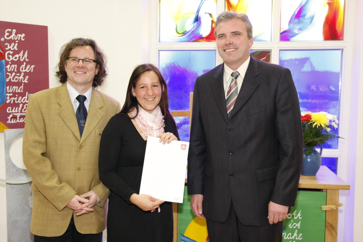 Foto: Fördermittelbescheid © Stadtverwaltung Erfurt Die Kitaleiterin zeigt voller Freude den Fördermittelöbescheid der Stadt Erfurt. Sie steht zwischen dem Leiter des Jugenddorfes und dem Oberbürgermeister.