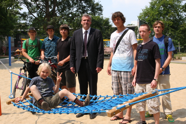 Foto: Oberbürgermeister Andreas Bausewein zum Fototermin mit Jugendlichen im Südparken © Stadtverwaltung Erfurt Hinter einer Hängematte, auf der ein Junge liegt, steht Oberbürgermeister Andreas Bausewein. Rechts und links von ihm stehen jeweils drei Jugendliche.