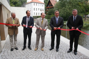 5 Herren durchschneiden ein rotes Band vor dem Mikweneingang