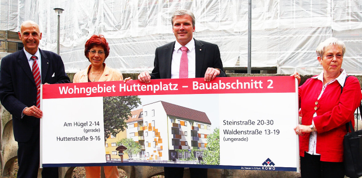 KoWo-Geschäftsführer Friedrich Herrmann, Aufsichtsratsvorsitzende Karola Stange, Oberbürgermeister Andreas Bausewein und Aufsichtsratsmitglied Margarete Hentsch zeigen auf gehaltenem Plakat, wie die sanierten Wohnhäuser in sieben Monaten aussehen werden.