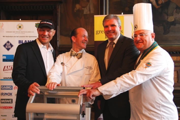 Foto: Olympiade der Köche in Erfurt: Auslosung der Teams © Stadtverwaltung Erfurt An der Lostrommel: "Glücksfee" Axel Schulz, Gissur Gudmundsson, der Präsident des Weltverbandes der Koch-Verbände (WACS), Oberbürgermeister Andreas Bausewein sowie Robert Oppeneder, Präsident des Verbandes der Köche Deutschlands e. V.