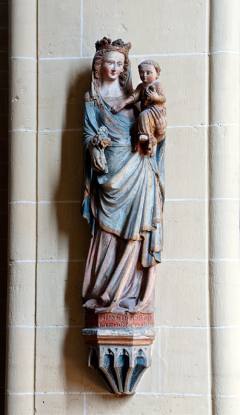 Eine in Stein gehauene Madonnen-Figur an einer Säule.