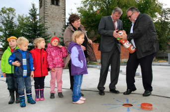 Oberbürgermeister Bausewein und AWO-Geschäftsführer Haack befüllen die Hülse mit Zeitdokumenten, um sie anschließend im Rohbau zu versenken.