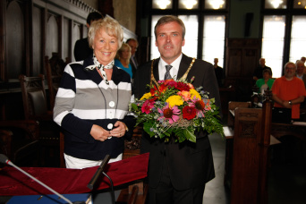 Dame aus dem Stadtrat überreicht dem Oberbürgermeister einen Strauß Blumen