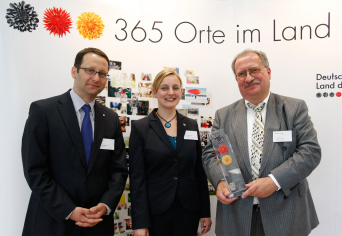 Jörg Siegel von der Deutschen Bank und Christina Janitz von der Standortinitiative "Land der Ideen" bei der Preisverleihung an Prof. Klaus Jantke, Abteilungsleiter Kindermedien am Fraunhofer Institut für Digitale Medientechnologie