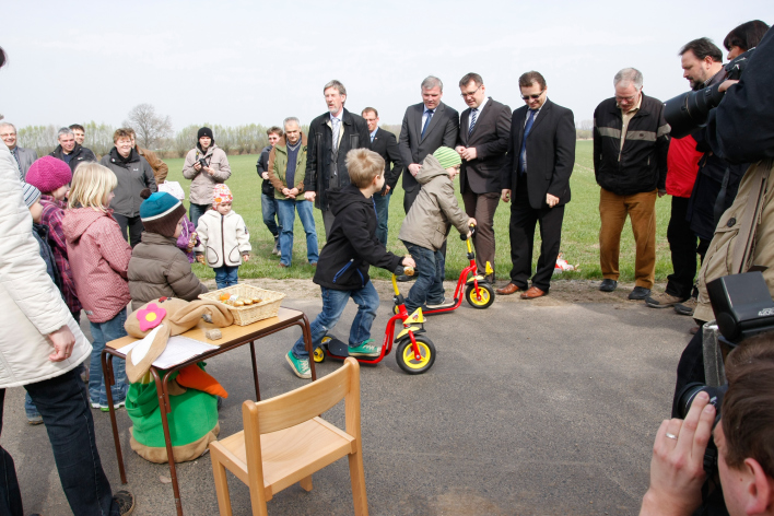 Kinder fahren auf Rollern auf dem neuen Weg