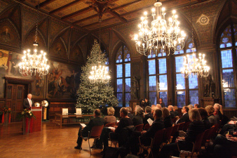 Rathausfestsaal mit Weihnachtsbaum und Publikum