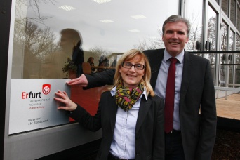 OB Bausewein und Kathrin Weiß bringen ein Schild mit der Aufschrift Standesamt am Mainzpavillon an. 