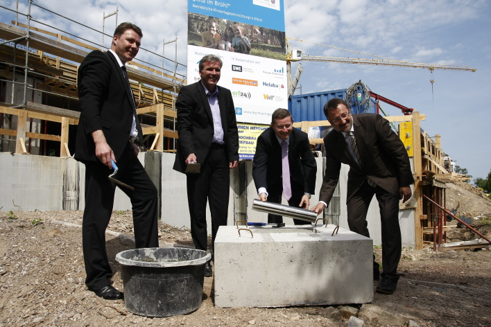 Foto: Grundsteinlegung Kita Brühl © Stadtverwaltung Erfurt Die Vertreter der Stadt, des Landes, der Thüringer Aufbaubank und der LEG versenken eine Edelstahl-Kapsel in einem Betonbett im Grundstein.