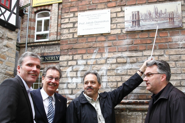 Die Initatoren stehen mit dem Oberbürgermeister vor der Gedenktafel, die in gut zwei Metern Höhe angebracht ist. Im Hintergrund sieht man den Eingang zur Marktstraße 6. 