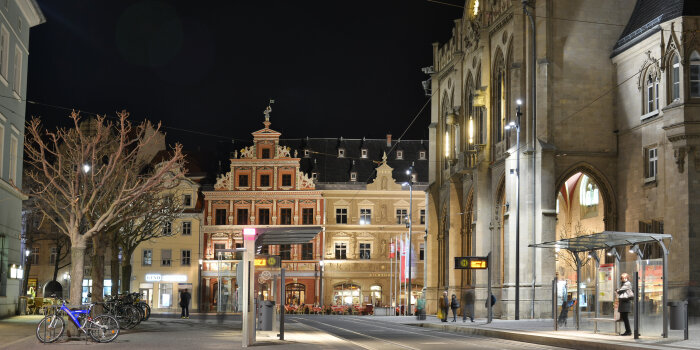 Umgestalteter Fischmarkt Nächtlicher Blick auf das Rathaus in Erfurt mit beleuchteter Fassade, davor eine barrierefrei gestaltete Straßenbahnhaltestelle.