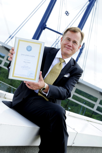 Der Geschäftsführer der Erfurter Messe präsentiert ein Zertifikat, dass seinem Unternehmen verliehen wurde.