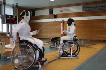 Zwei im Rollstuhl sitzende Fecht-Sportler im Duell.