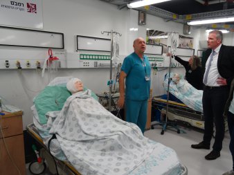 Ein Arzt und Oberbürgermeister Andreas Bausewein auf einer Schaustation des Krankenhauses Rambam mit zwei Betten in denen Puppen liegen. 