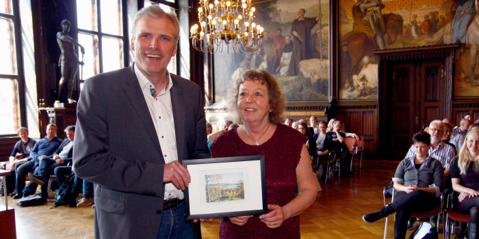 Die Porjektkoordinatorin von norwegischer Seite überreicht dem Oberbürgermeister ein Bild als Gastgeschenk.